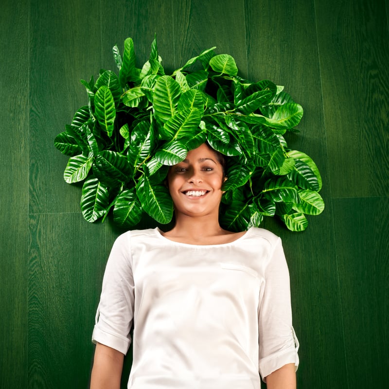 Frau mit grünen Blättern auf dem Kopf